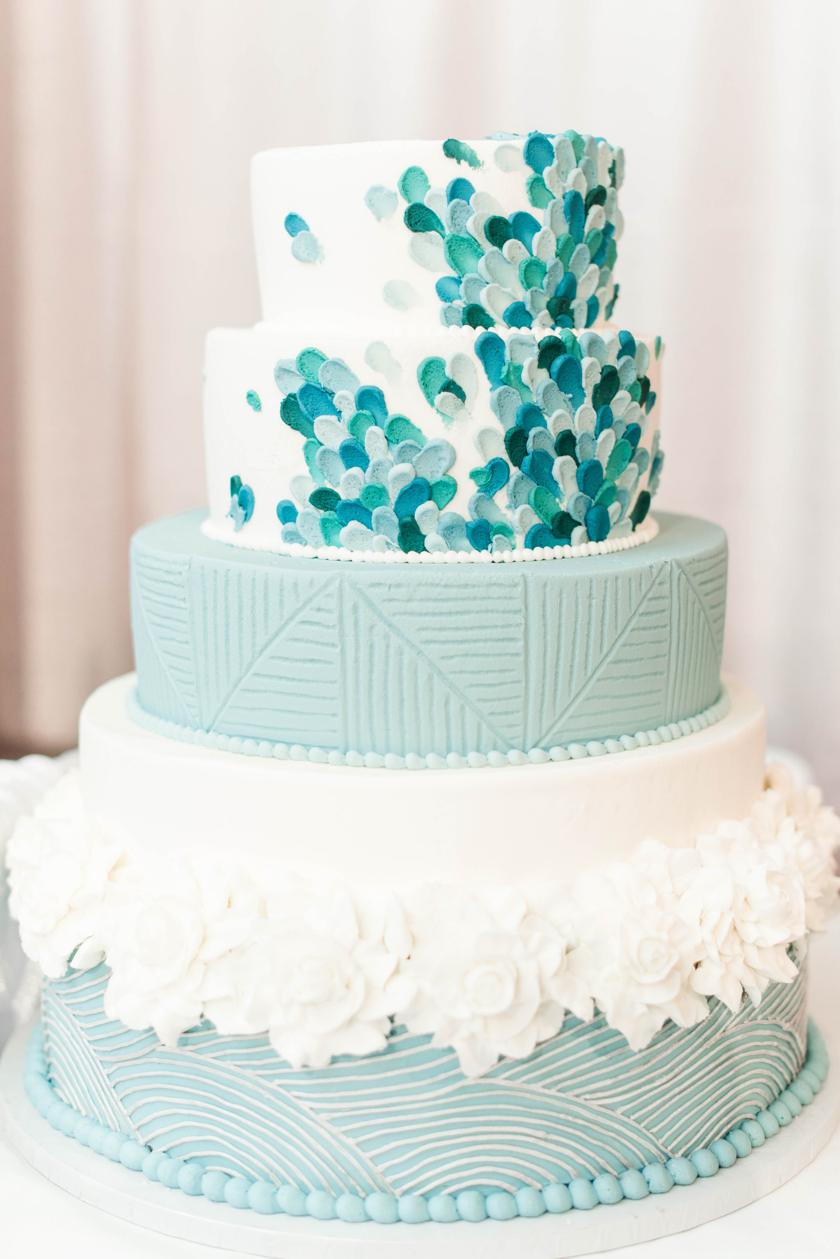 A five-tier custom wedding cake with hand-painted detailing and sugar flowers